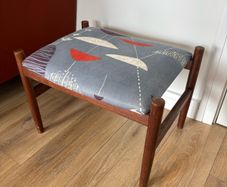Mid Century Style Wooden Footstool / Ottoman with retro atomic-inspired upholstered seat.