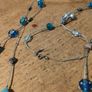 long necklace featuring a mix of blue-toned glass beads and silver-colored accent beads on a thin gray cord Image 4