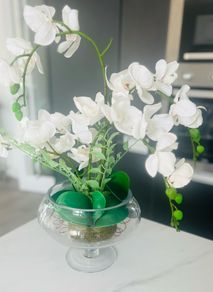 Decorative artificial Phalaenopsis orchid arrangement set in a clear glass vase