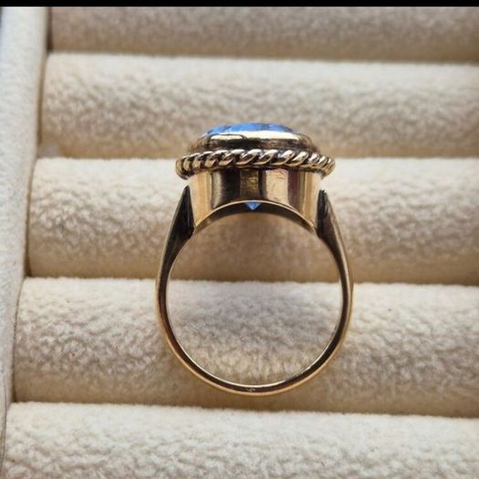 Beautiful 9K gold ring featuring a stunning large oval blue stone.