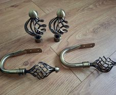 Decorative pair of antique brass cage swirl curtain hold backs with matching finials
