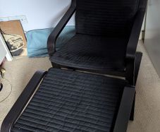 Black IKEA poaug armchair and footstall