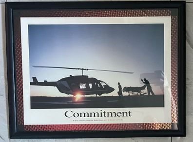 Framed Motivational Commitment Photo showing silhouette patient being loaded into helicopter by ambulance crew.