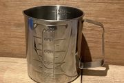 Stainless steel measuring beaker with a handle