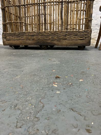 Large Victorian cane and metal laundry basket on wheels.