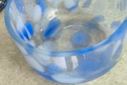 A hand-blown blue and white swirl art glass piece Small glass bowl with sticker say The phrase "EVERY PIECE IS UNIQUE" circles the clover.