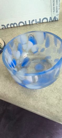 A hand-blown blue and white swirl art glass piece Small glass bowl with sticker say The phrase "EVERY PIECE IS UNIQUE" circles the clover.
