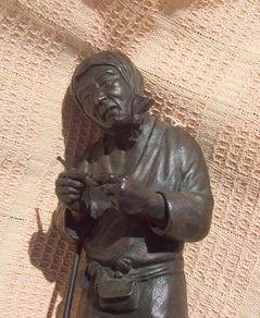An antique bronze Japanese sculpture (Meiji era) - a finely made sculpture of a Japanese peasant with smoking pipe & hoe (late 19th century)