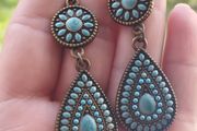 Vintage-style long bohemian drop earrings featuring turquoise enamel and a bronze-tone metal finish.