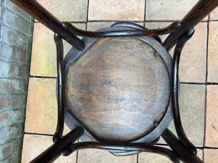 A vintage 1920s Thonet style bentwood chair with armrests.