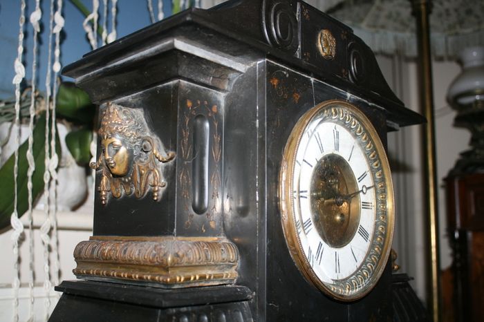 Victorian French Black Slate Mantle Clock (Very large and heavy) with bronze ornamentation Oversized. Open escarpment slate plate Roman numerals. Circa 1890s. Accented with Trojan head. Flanked by two Hellenistic ladies heads on sides. Rose cartouche mask
