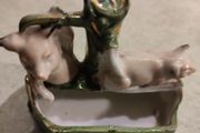 figurine of two pigs cooling down at bone china  water pump.