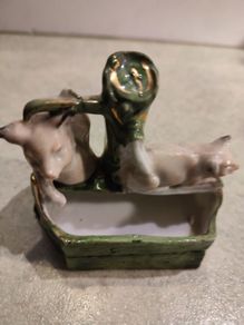 figurine of two pigs cooling down at bone china  water pump.