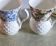 Set of 2 mugs decorative porcelain  fine bone china featuring a distinct textured, quilted or honeycomb base and intricate floral patterns.