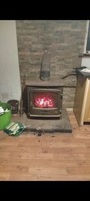 Hertage log burner stove good size works as should fluet pipe and surround with it