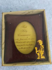 wooden photo frame commemorative plaque for a First Holy Communion. The plaque features an oval-shaped insert with a message and a small golden figure of a child praying.