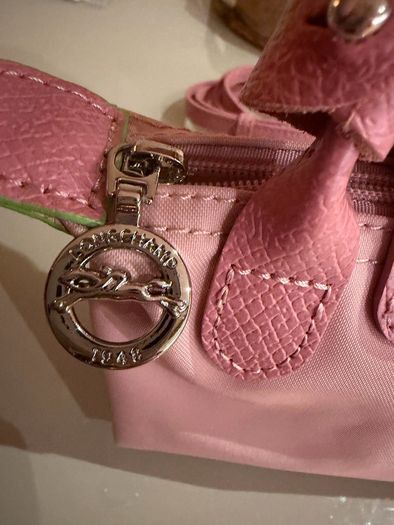 pink Longchamp Le Pliage mini top-handle bag with a detachable shoulder strap