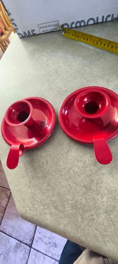 Set of 2  Red enamel candlestick holder and drip tray featuring a Considered by Helen James 12.00 euro each.