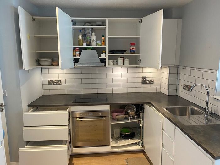 Modern white kitchen units and tall larder storage