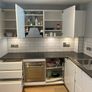 Modern white kitchen units and tall larder storage Image 4