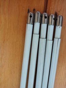Five white extendable net curtain rods