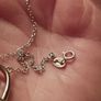 A silver bracelet with a heart-shaped pendant featuring a horse and foal's head. Image 4