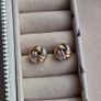 Beautiful silver and rose gold-tone knot stud earrings. Image 6