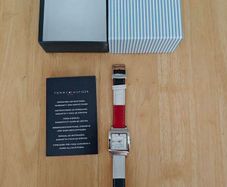 Tommy Hilfiger watch features a distinctive rectangular stainless steel case and a reversible red, white, and blue leather strap