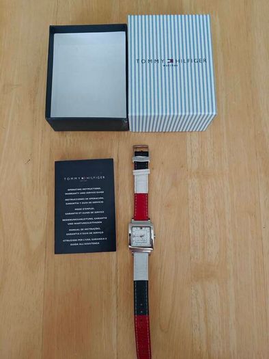 Tommy Hilfiger watch features a distinctive rectangular stainless steel case and a reversible red, white, and blue leather strap