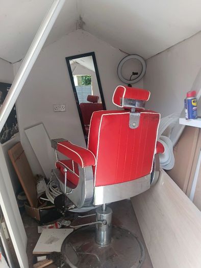 Beautiful red vintage Barbers chair with white piping