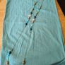 long, colorful beaded necklace featuring a mix of wood, blue, and white floral beads. Image 4