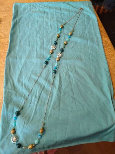 long, colorful beaded necklace featuring a mix of wood, blue, and white floral beads.