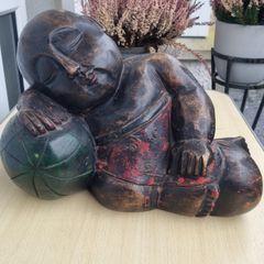 A large wooden statue of a sleeping Buddha