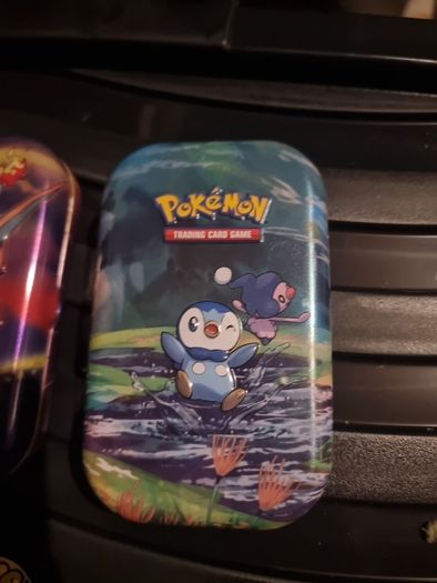 Three Pokemon tins with two coins.