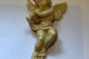 Vintage wall-mounted resin figurine of a cherub playing a trumpet