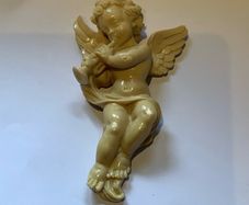 Vintage wall-mounted resin figurine of a cherub playing a trumpet