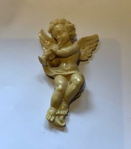 Vintage wall-mounted resin figurine of a cherub playing a trumpet