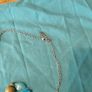 long, colorful beaded necklace featuring a mix of wood, blue, and white floral beads. Image 5