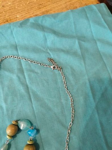 long, colorful beaded necklace featuring a mix of wood, blue, and white floral beads.