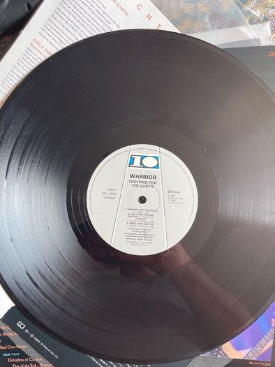 WARRIOR Fighting for the earth original 1985 release with inner lyric sheet vinyl record in near mint condition. Sleeve is vg with just some light wear along top of spine otherwise it would be nm