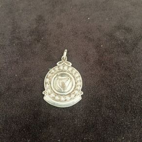 A silver medal or pendant depicting the Irish harp