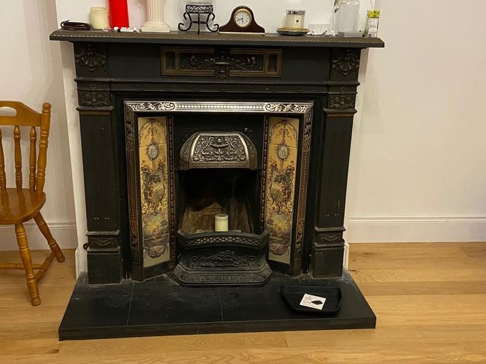 Late Victorian / early Edwardian style cast iron fireplace with tiled inserts and a decorative mantel surround