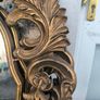 large, ornate gold mirror features a baroque frame Image 4