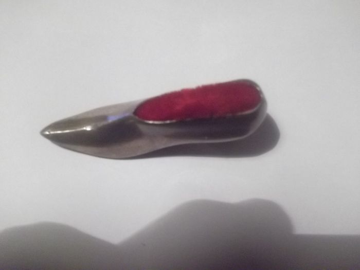a vintage solid silver pin cushion in the shape of a shoe