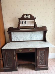 late Victorian or Edwardian mahogany mirror-back washstand featuring a white Carrara marble top and a matching marble splashback gallery.