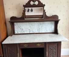 late Victorian or Edwardian mahogany mirror-back washstand featuring a white Carrara marble top and a matching marble splashback gallery.