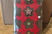 handcrafted wooden  Fairy door with red cardstock, brown flower cutouts, and decorative buttons.  various buttons acting as handles or embellishments.