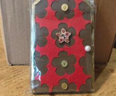 handcrafted wooden  Fairy door with red cardstock, brown flower cutouts, and decorative buttons.  various buttons acting as handles or embellishments.