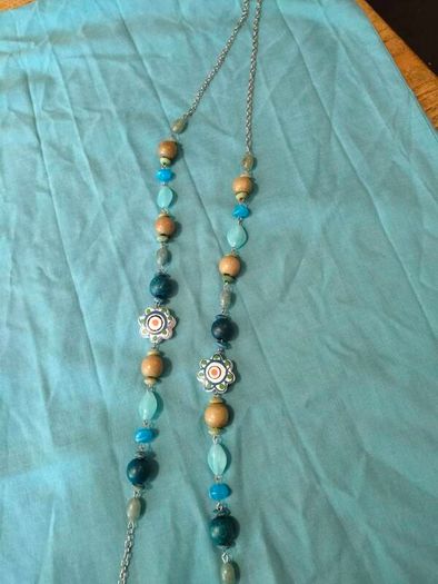 long, colorful beaded necklace featuring a mix of wood, blue, and white floral beads.