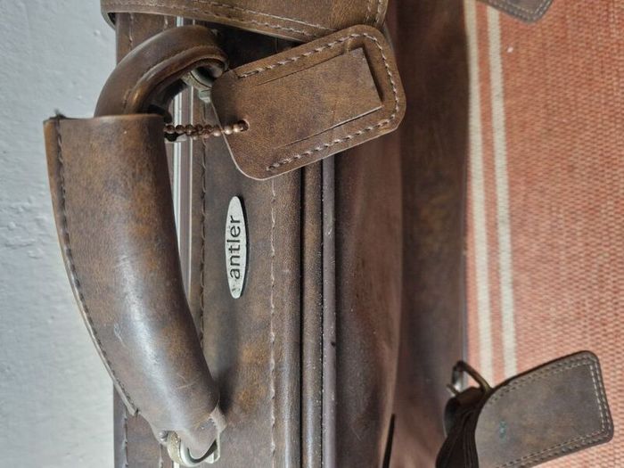 1leather suitcase and 1 faux leather suitcase.